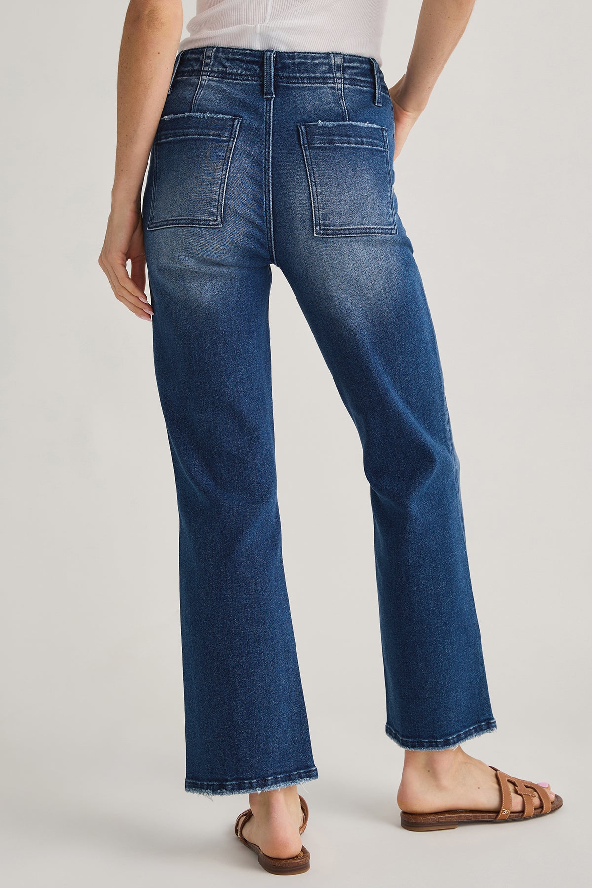 Back view ankle flare jeans in medium blue with yoke stitching and back patch pockets