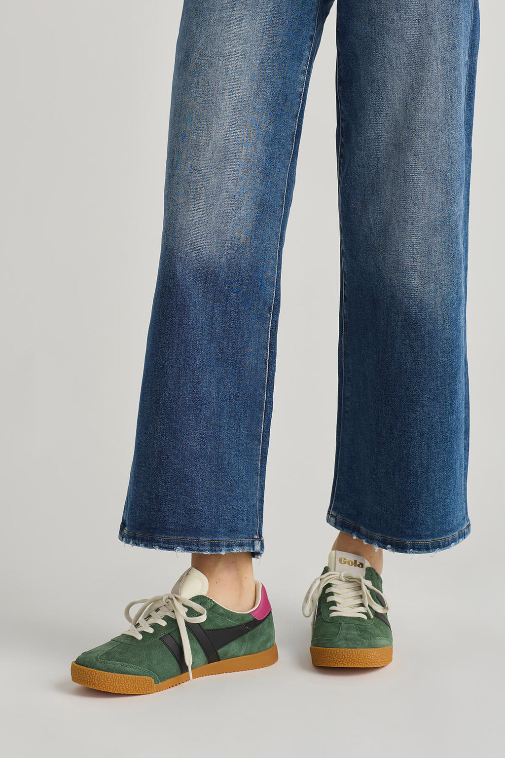Green lace-up low-top sneakers with white stripes and tan gum sole, front view