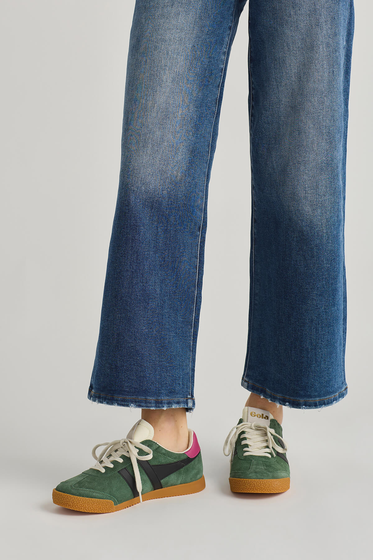 Green lace-up low-top sneakers with white stripes and tan gum sole, front view