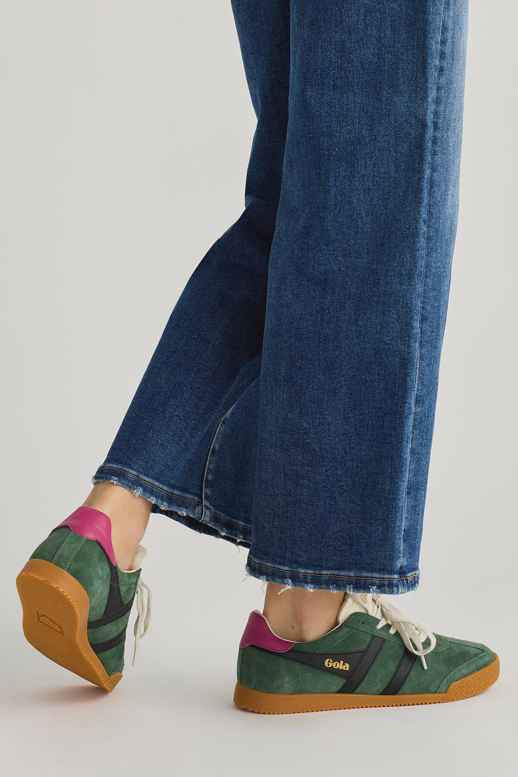 Green low-top sneakers with purple heel accent and tan rubber sole, profile view