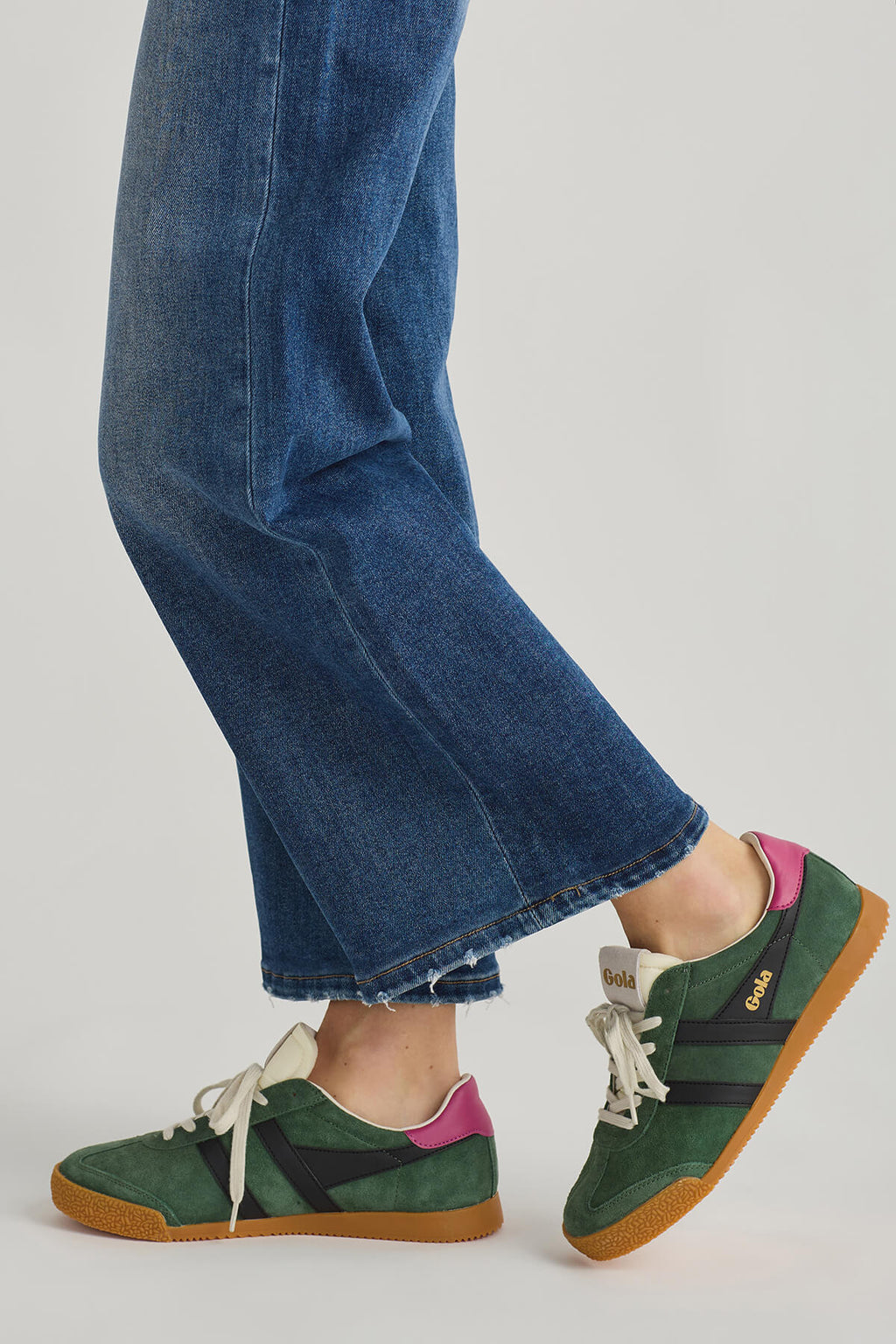Green low-top sneakers with white laces and purple heel accent, gum sole
