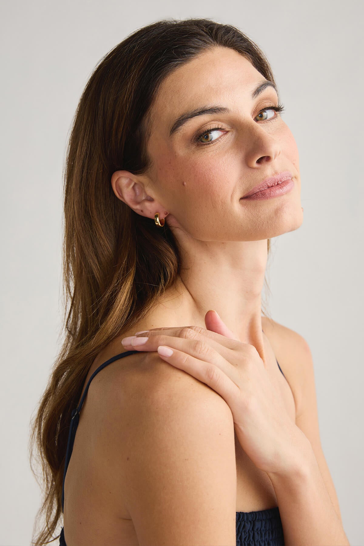 Gold hoop earrings with squared center cutout on ear