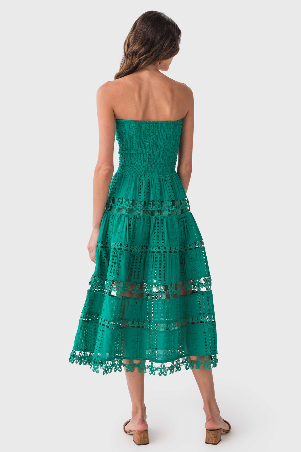 Back view of emerald green eyelet lace tube dress with tiered skirt and smocked bodice