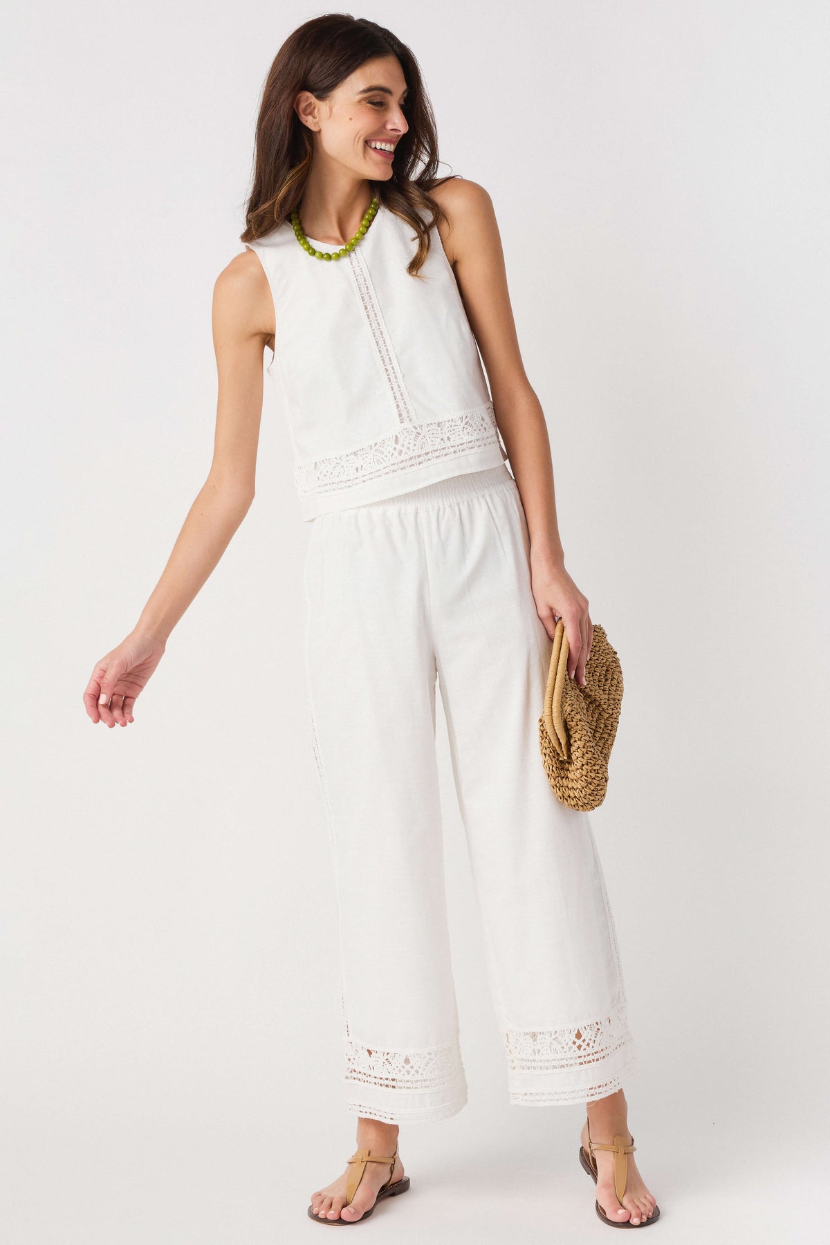 White embroidered wide-leg pants with scalloped eyelet hem and front seam detail