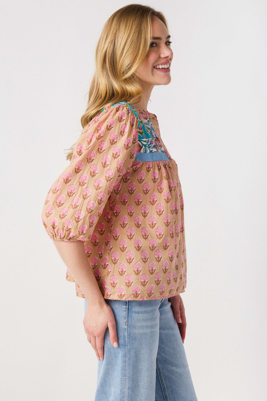 Women’s pink block print top with teal trim, puff sleeves, and keyhole neckline