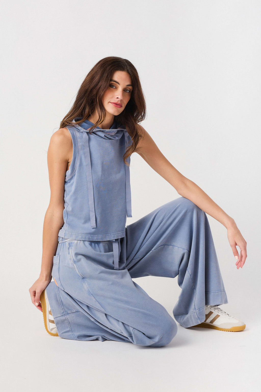 Light blue sleeveless hoodie top with drawstring, paired with wide-leg pants