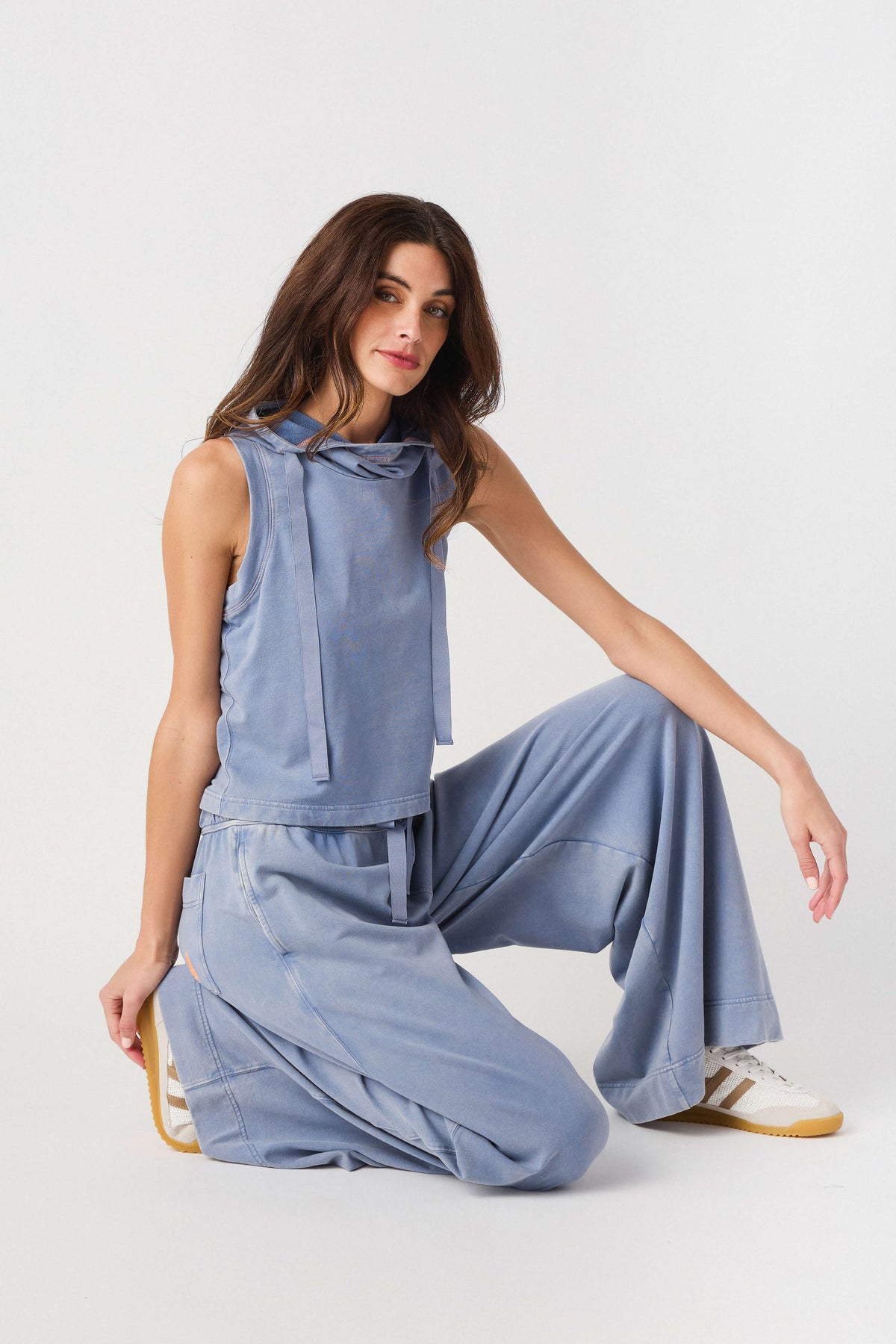 Light blue sleeveless hoodie top with drawstring, paired with wide-leg pants