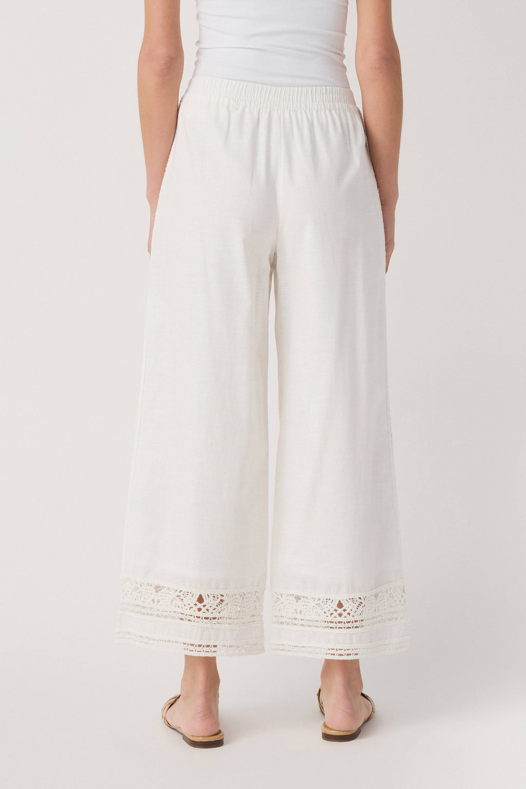 White wide-leg pants with gathered waistband and embroidered eyelet hem trim