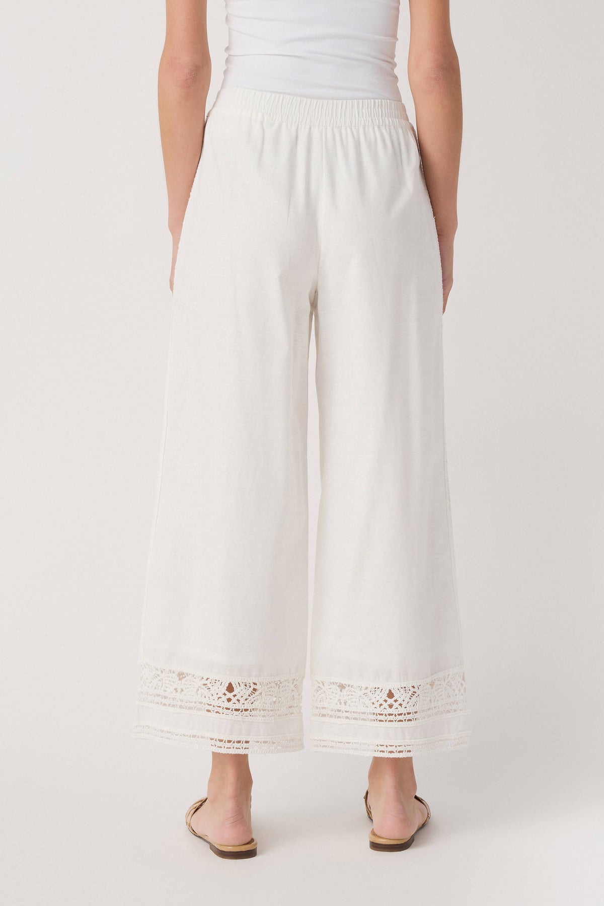 White wide-leg pants with gathered waistband and embroidered eyelet hem trim
