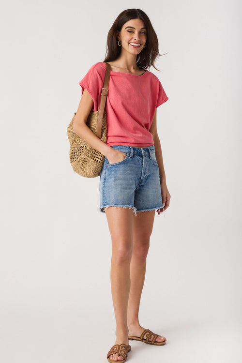 High-rise medium-wash denim shorts with raw frayed hem and front pockets