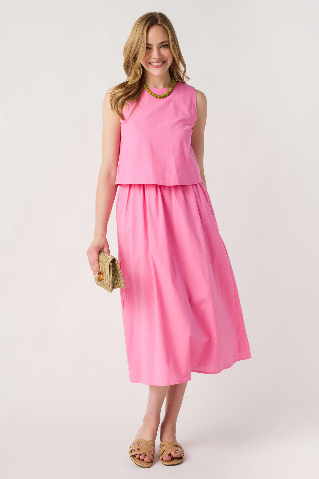 Pink layered midi dress, sleeveless top with green-trimmed neckline and tiered skirt