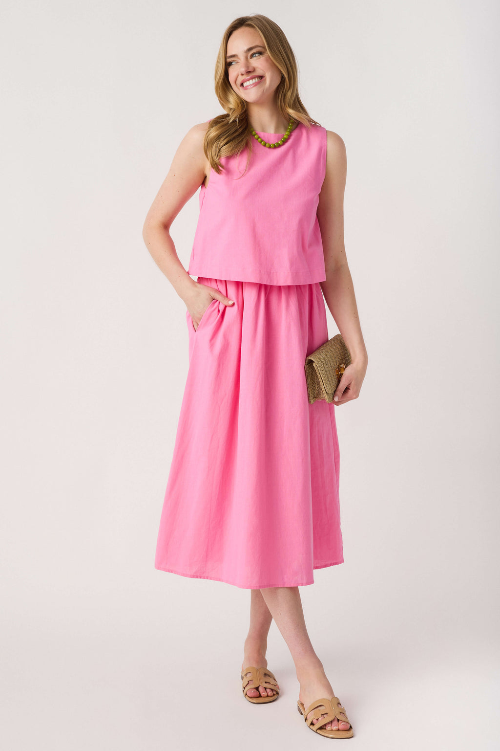 Pink layered midi dress, sleeveless with round neck and green trim