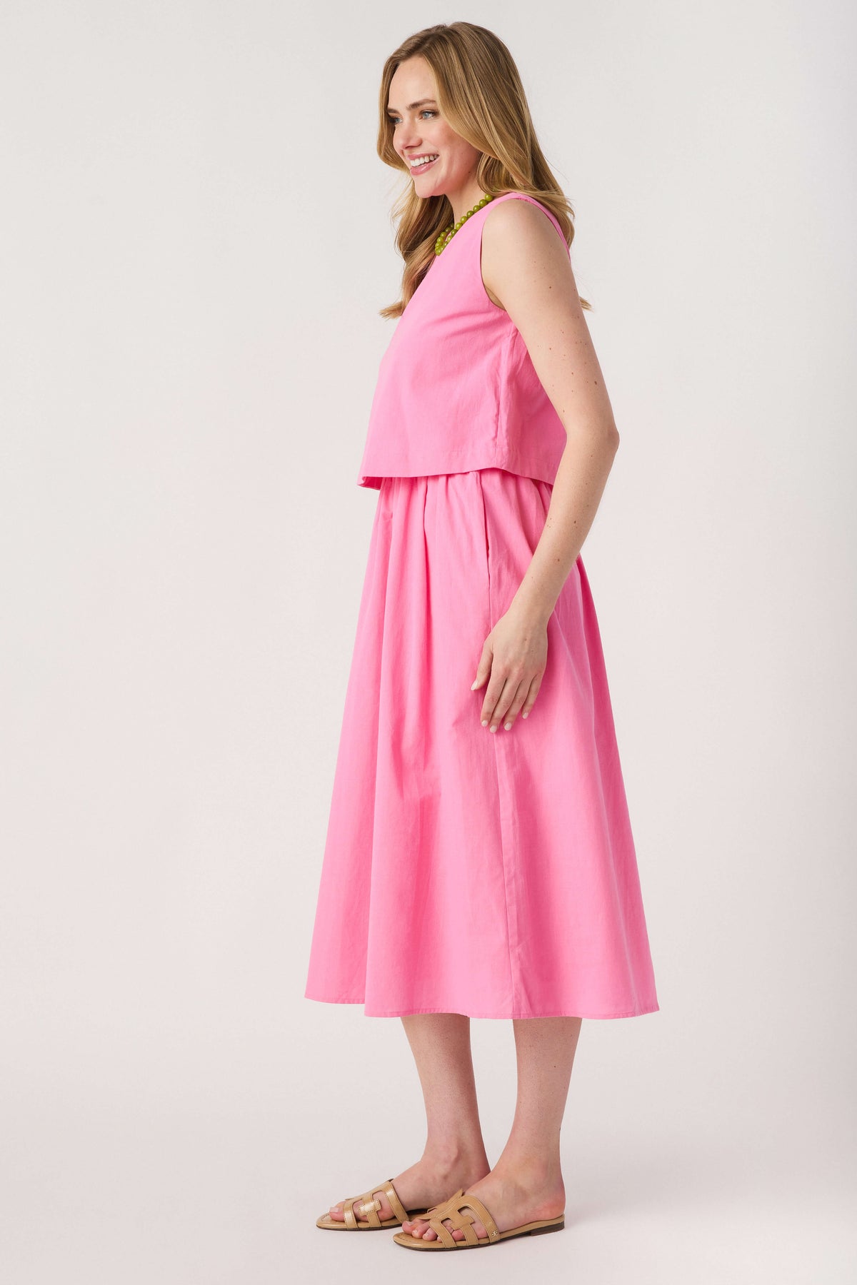 Pink sleeveless layered midi dress with green-trimmed round neckline
