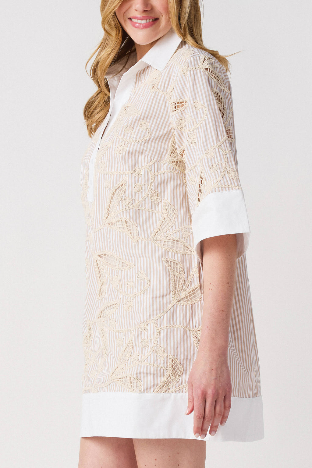 Floral embroidered shirt dress detail with white button placket and collar; light taupe pattern.