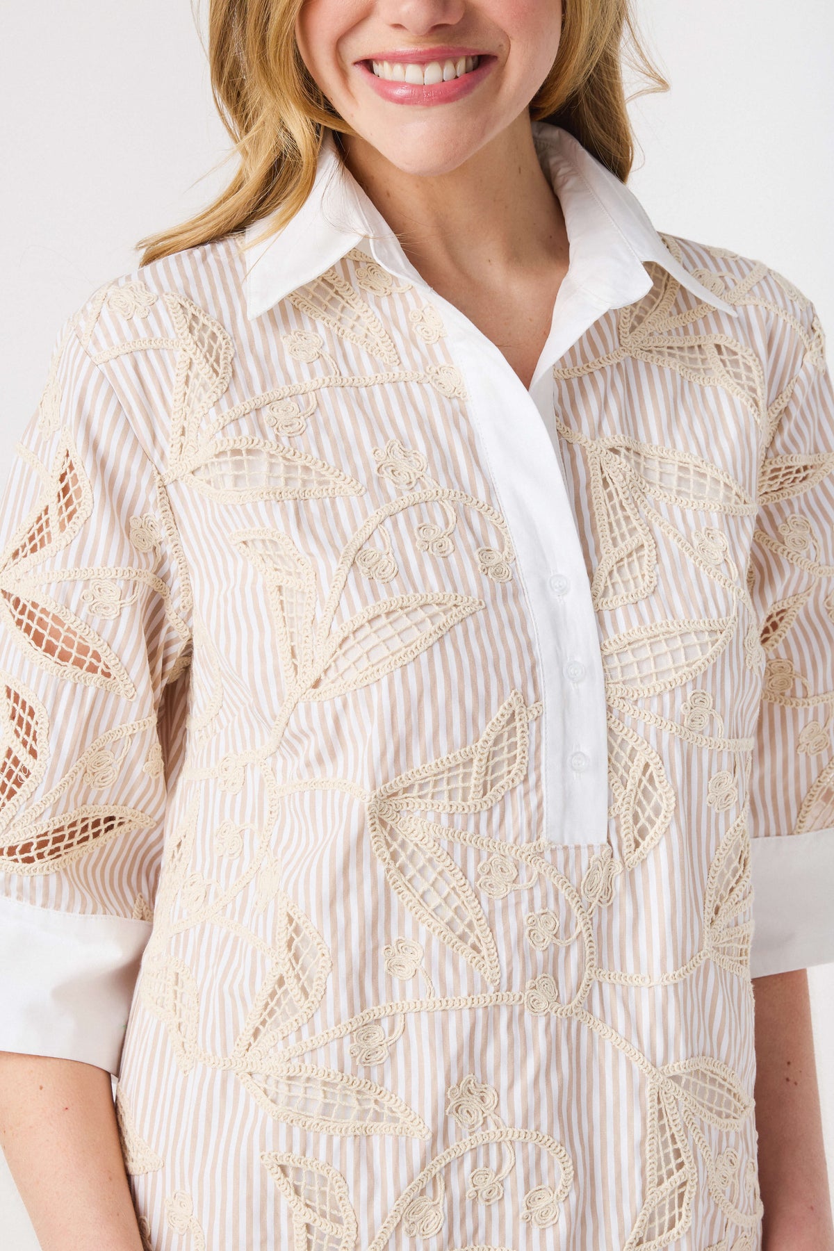 Floral embroidery shirt dress close-up with white collar and placket; light taupe pattern.