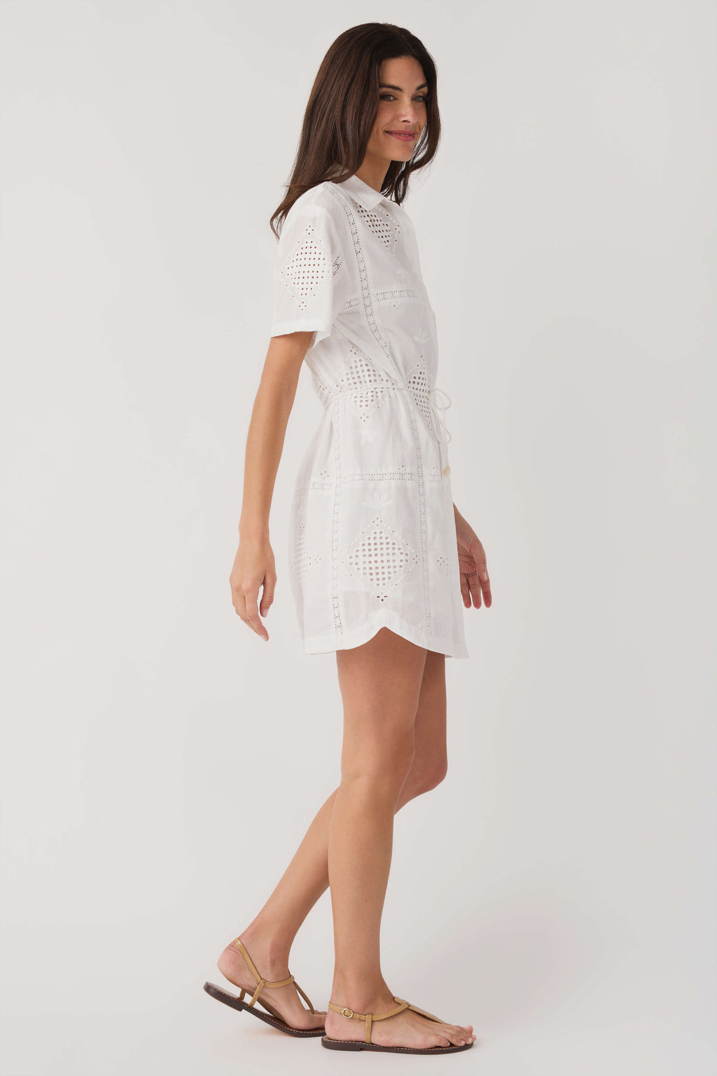 White eyelet mini dress with short sleeves and belted waist tie, side view