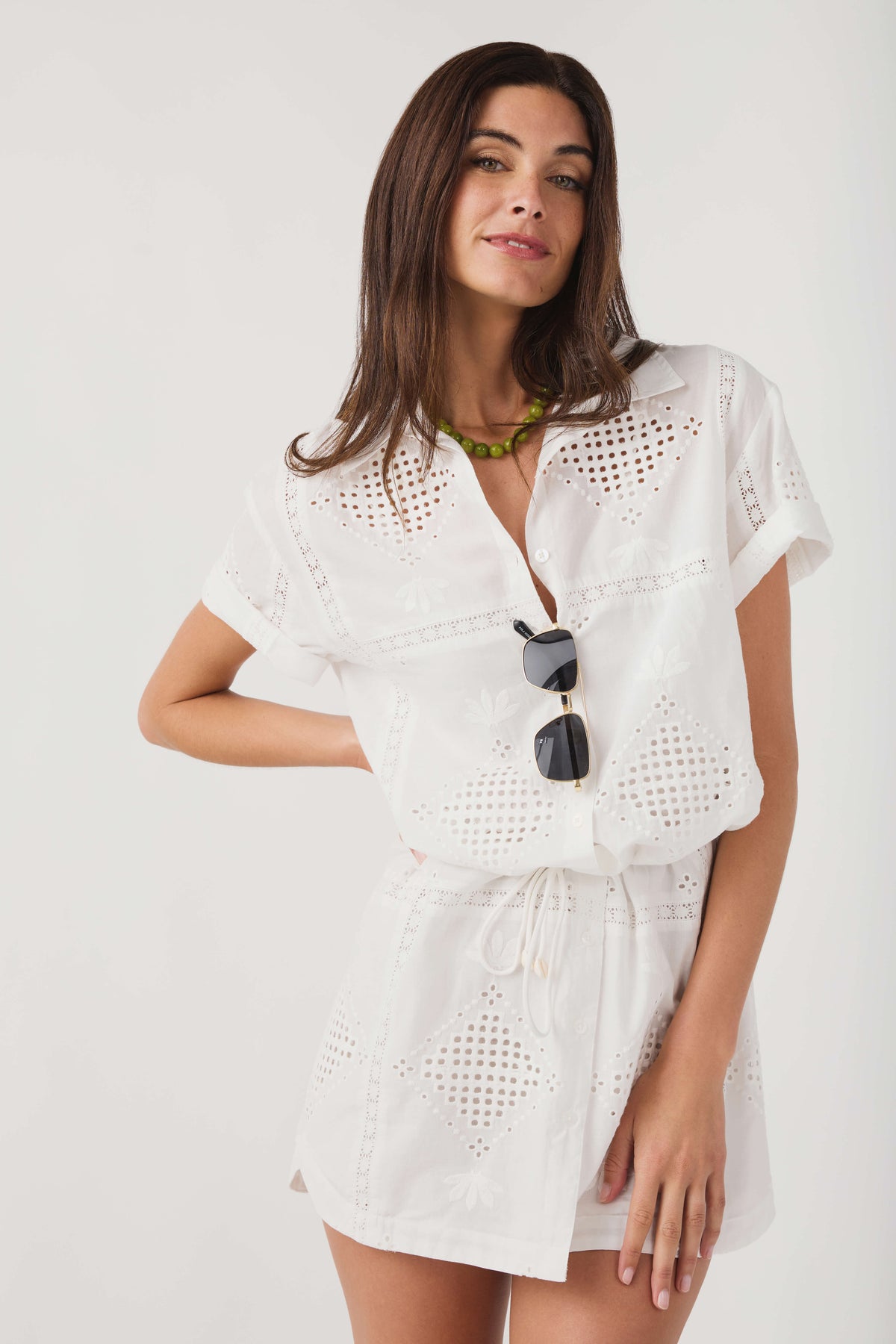 White eyelet mini dress with collared V-neck and drawstring waist tie