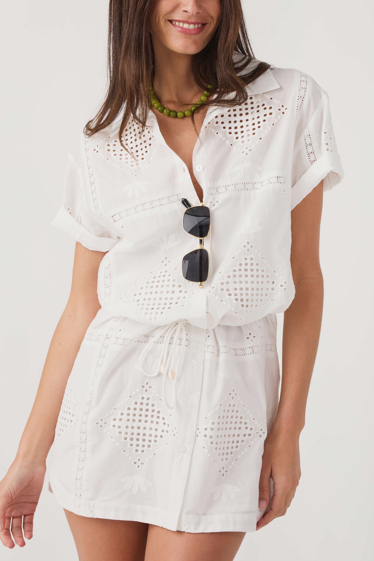 White eyelet mini dress with button-front V-neck and gathered drawstring waist