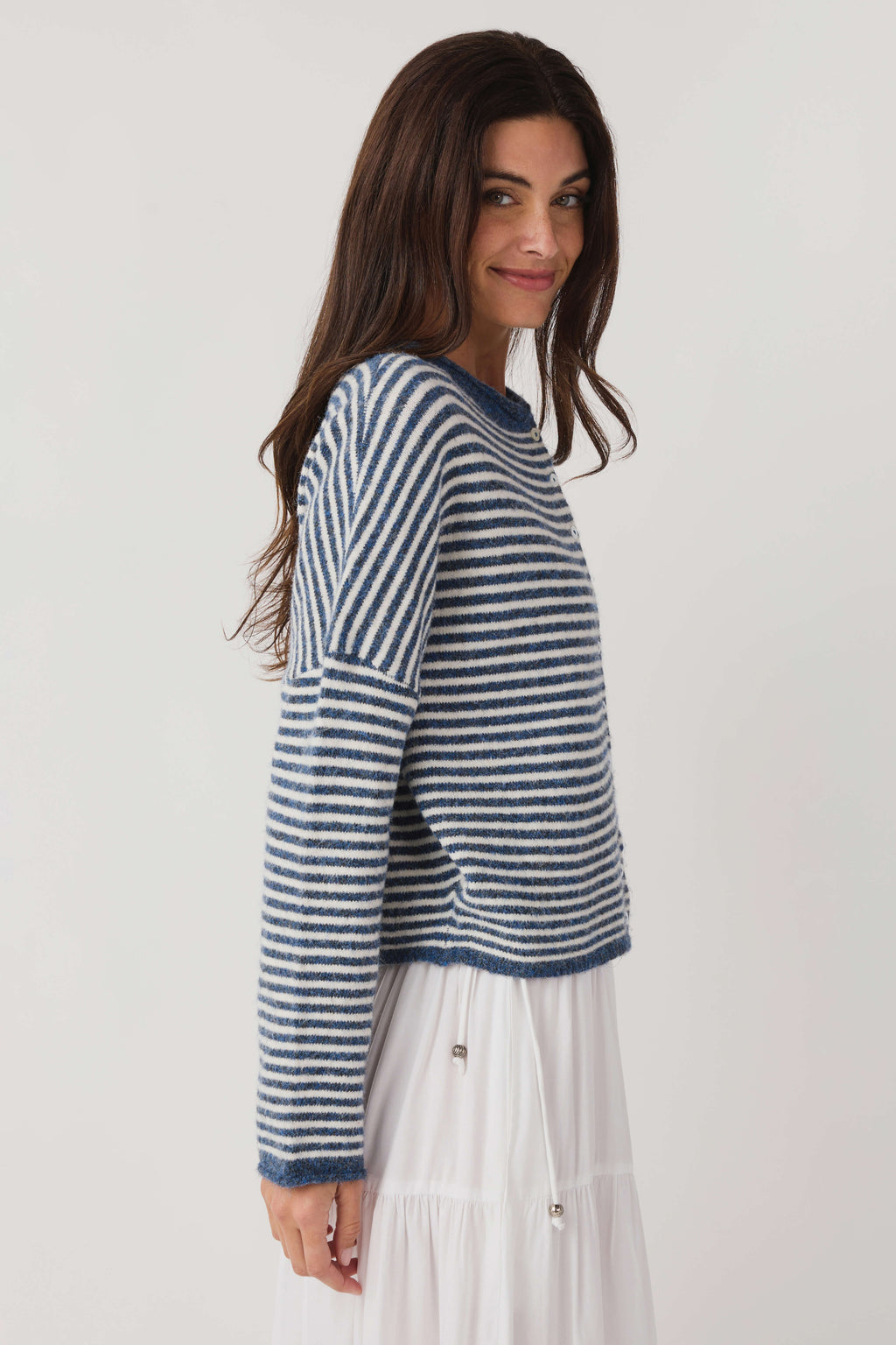 Striped knit cardigan angled side view; blue-and-white horizontal stripes, button front
