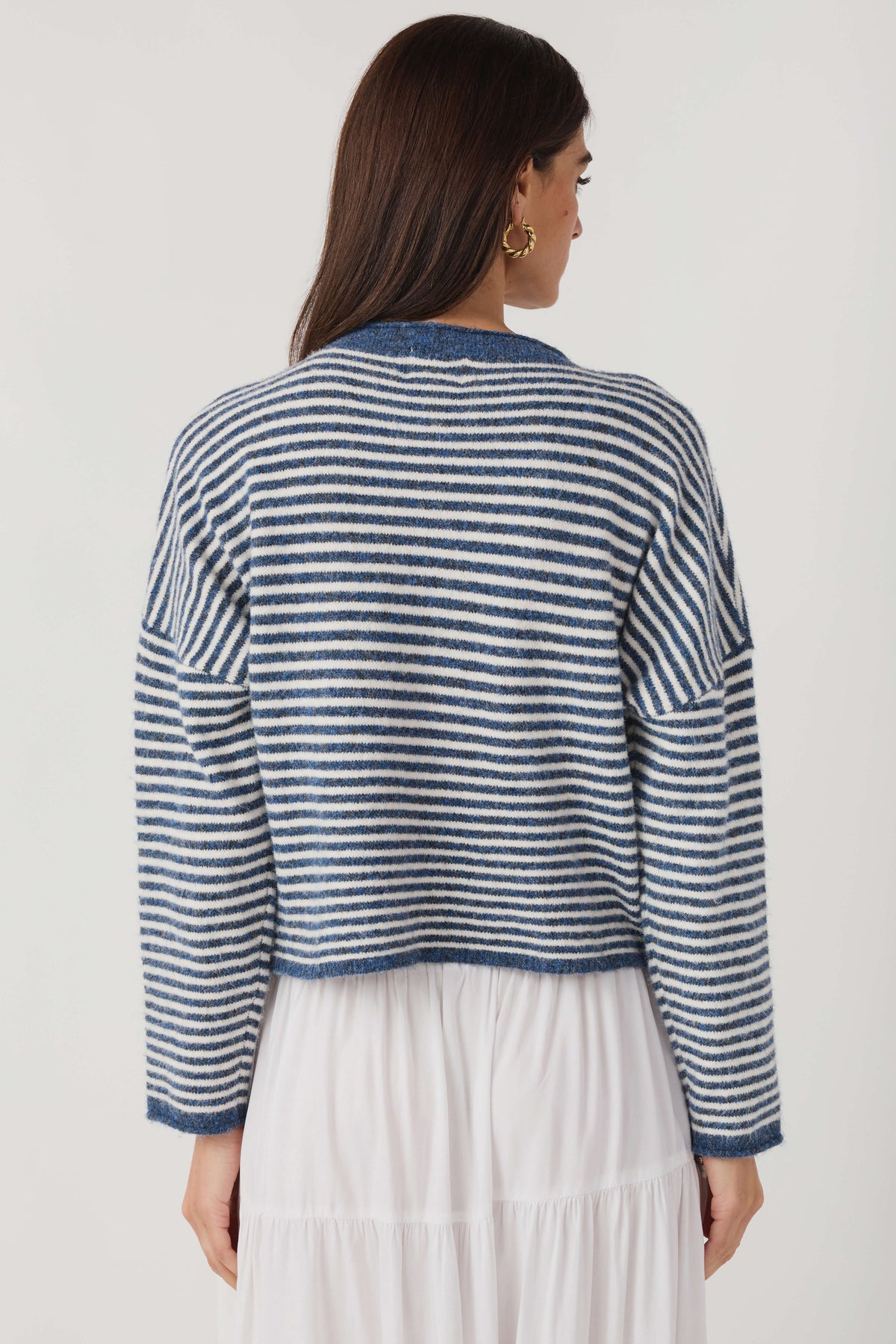 Striped knit cardigan, back view; blue-and-white horizontal stripes and button detail