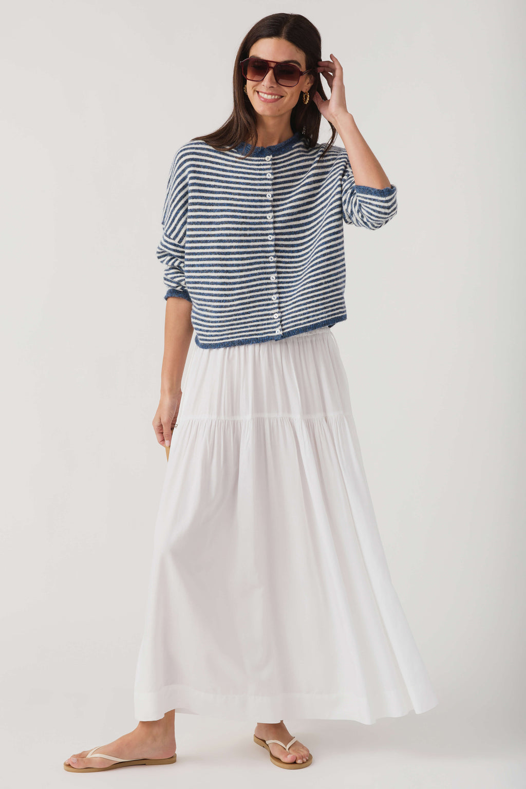 Striped knit cardigan with button front and relaxed sleeves; blue-and-white horizontal stripes