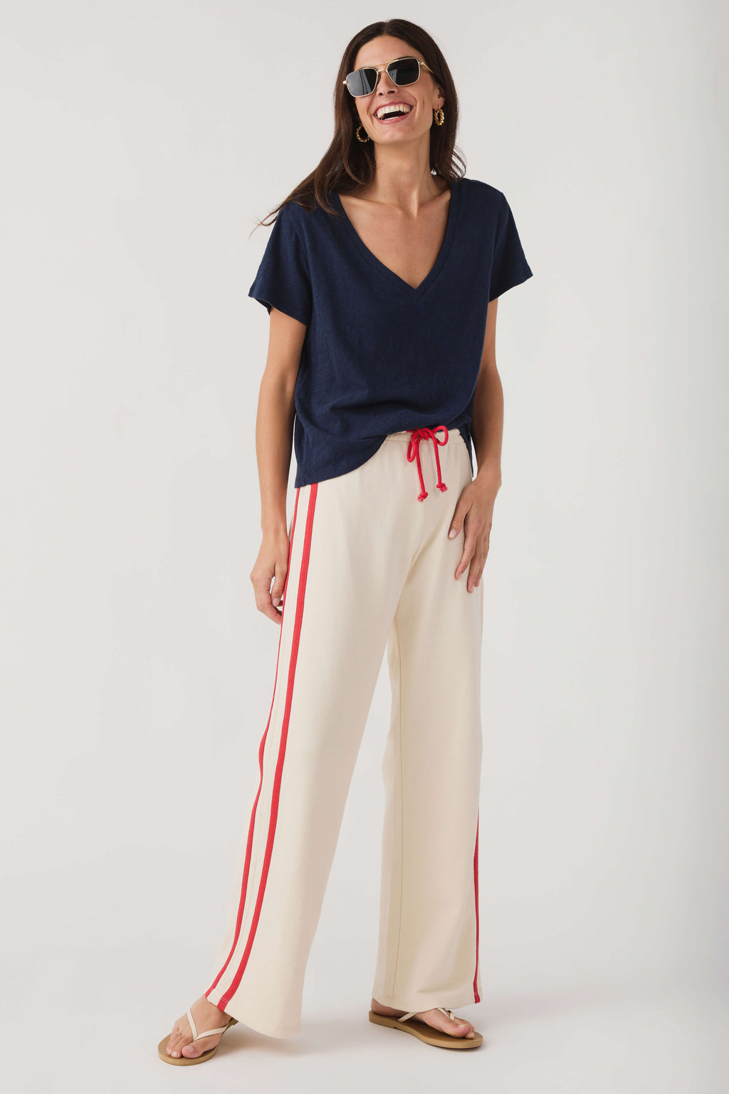 Cream wide-leg pants with red stripes and drawstring waist, casual styling