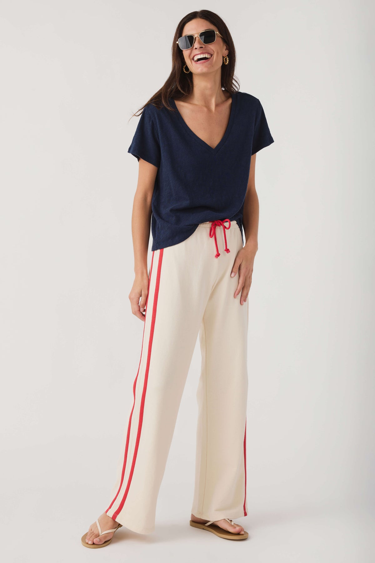 Cream wide-leg pants with red stripes and drawstring waist, casual styling