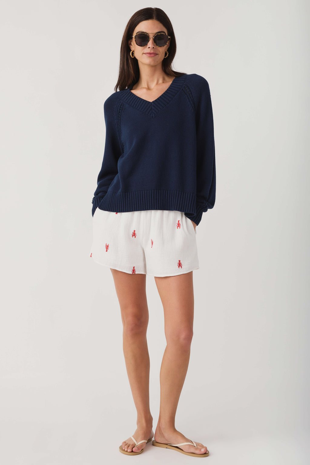 Women's navy V-neck knit sweater with ribbed hem, cuffs, and relaxed fit