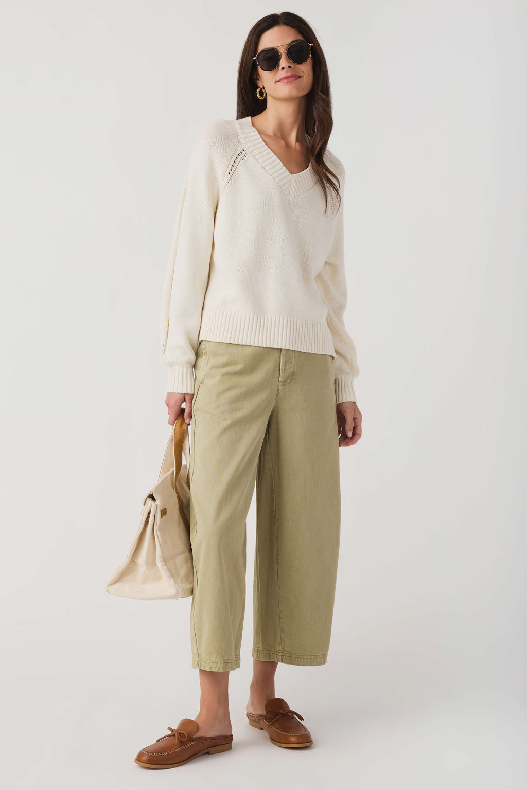 Ivory chino pants with a relaxed cropped fit, belt loops, and front button closure