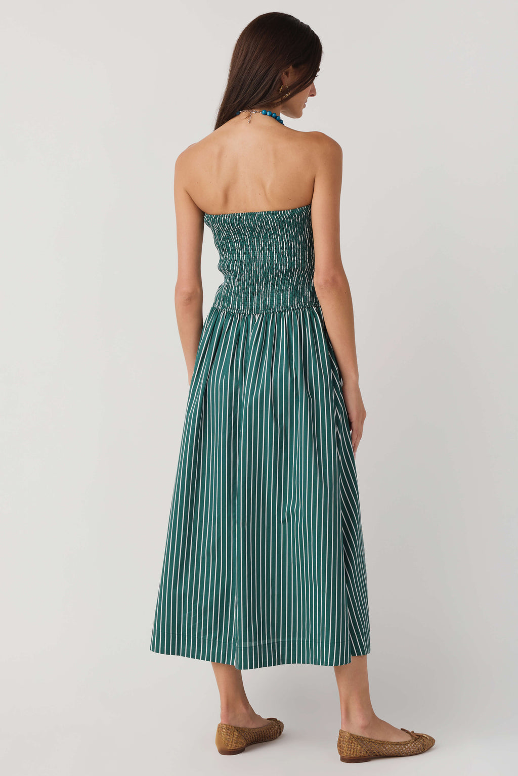 Back view of hunter green striped strapless midi dress with smocked gathered waist