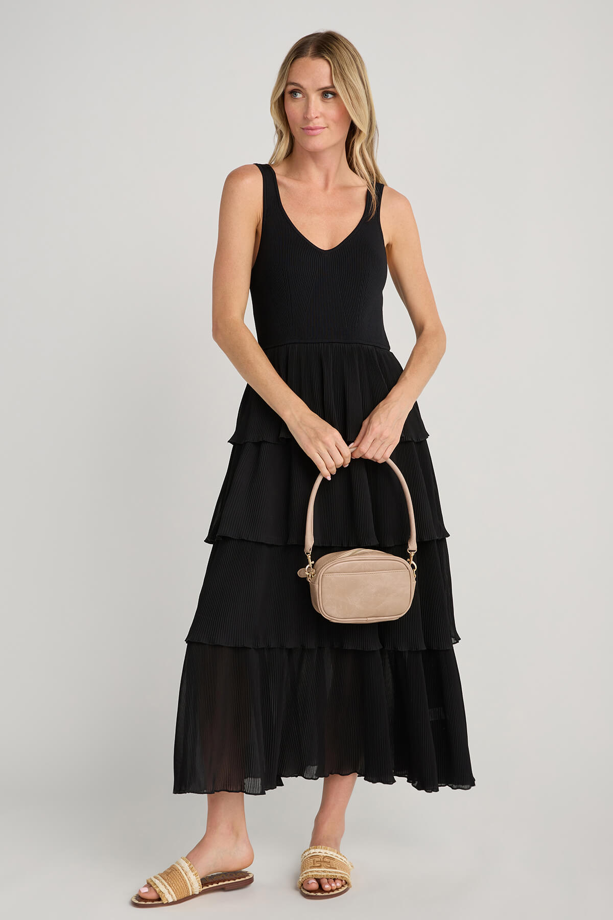Tan tube strap on small crossbody bag with gold-tone clasp hardware