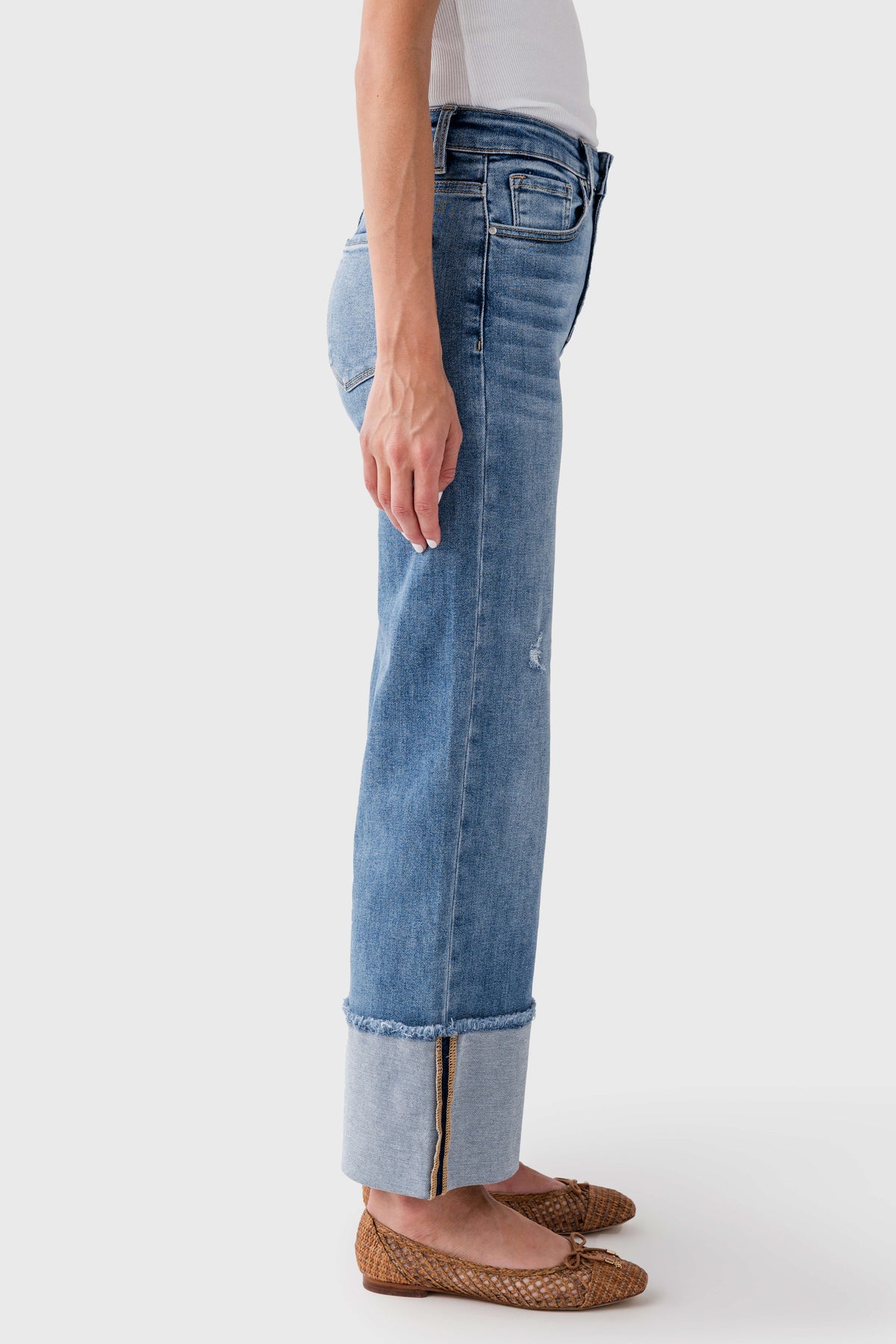 Medium-wash cuffed jeans shown from the side, ankle-length with hem cuff