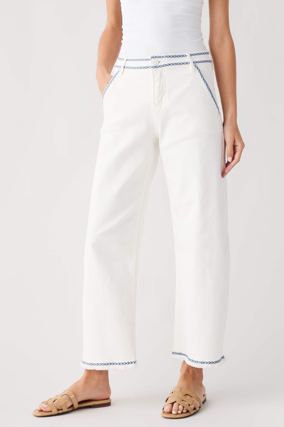 Cream embroidered cropped barrel jeans with blue trim at cuffs and hems