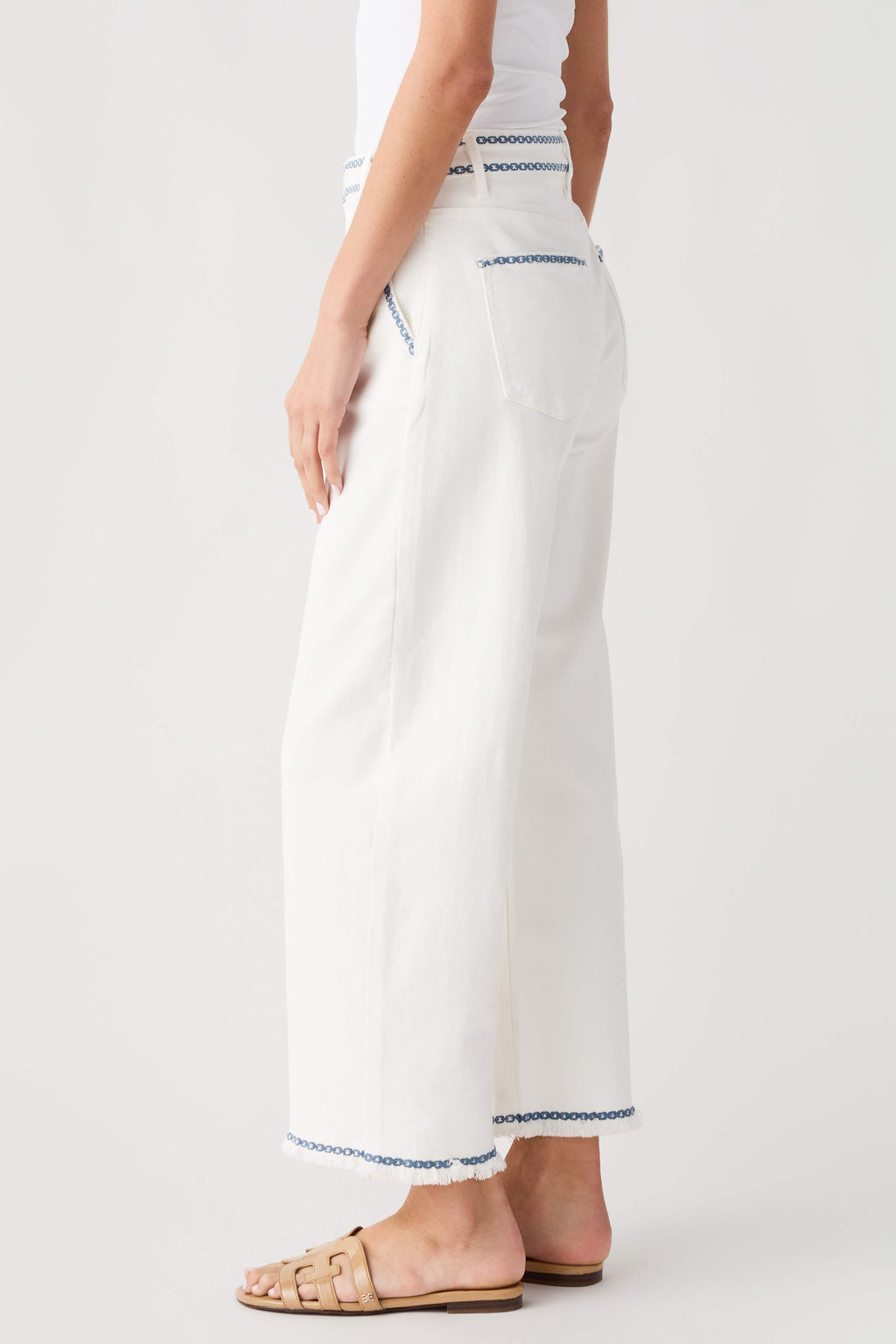 Cream embroidered cropped barrel jeans with blue trim along hem
