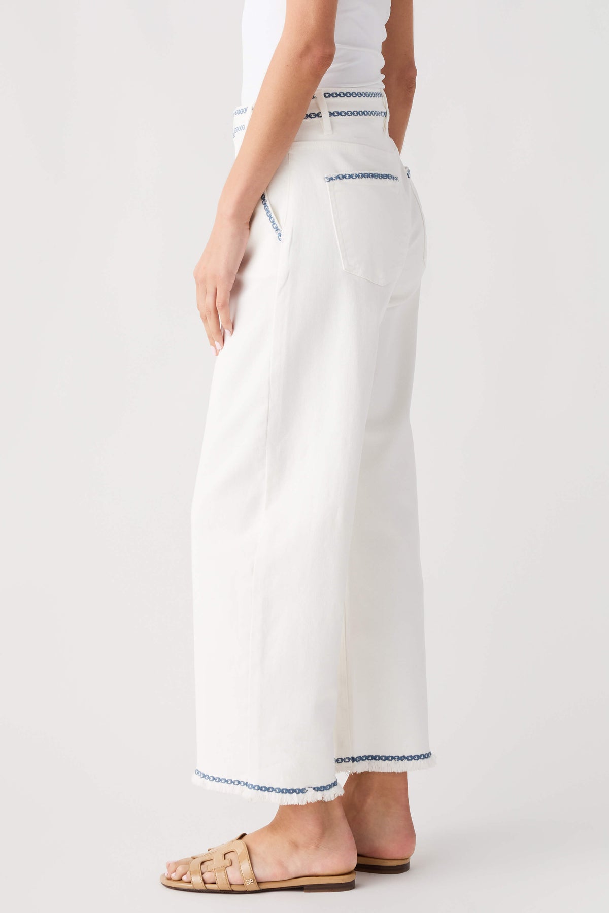 Cream embroidered cropped barrel jeans with blue trim along hem