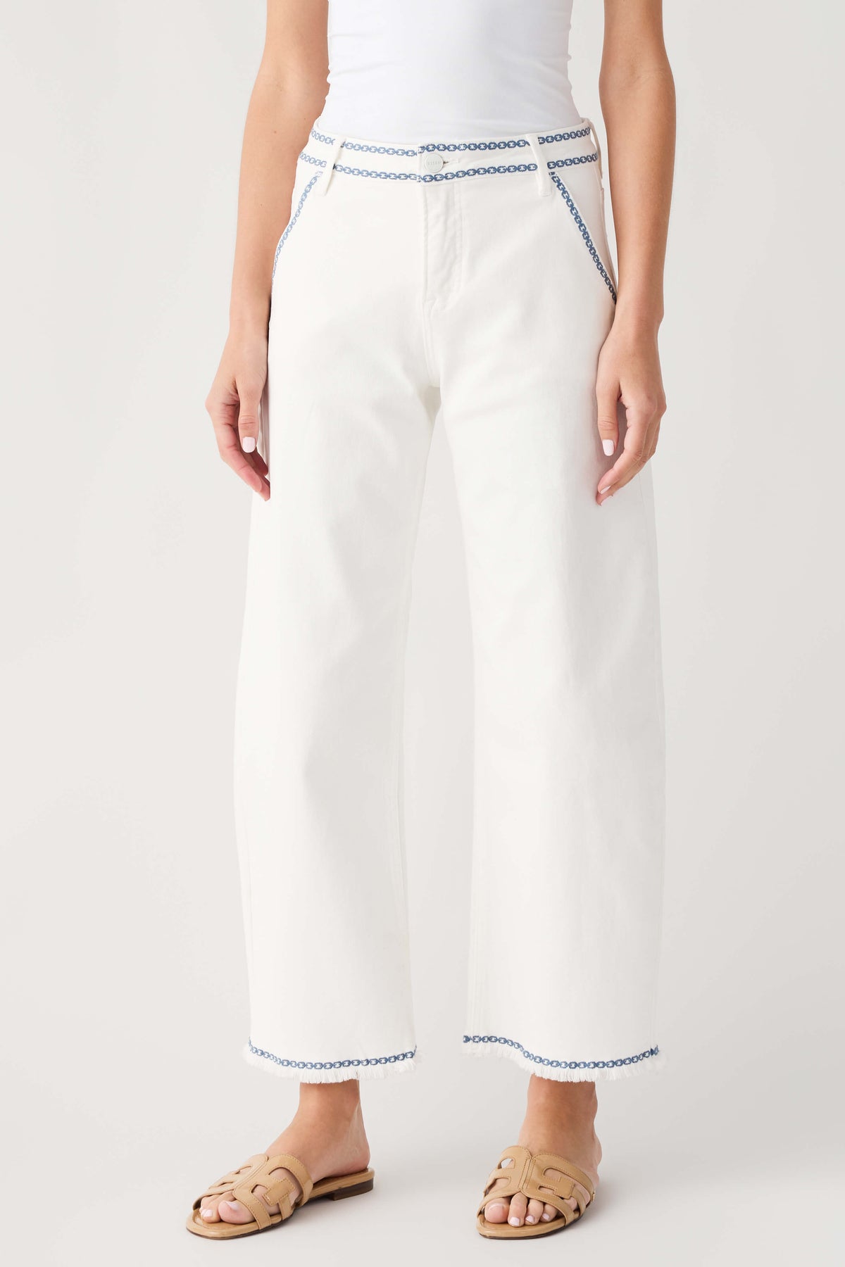 Cream embroidered cropped barrel jeans with blue trim at waistband and cuffs