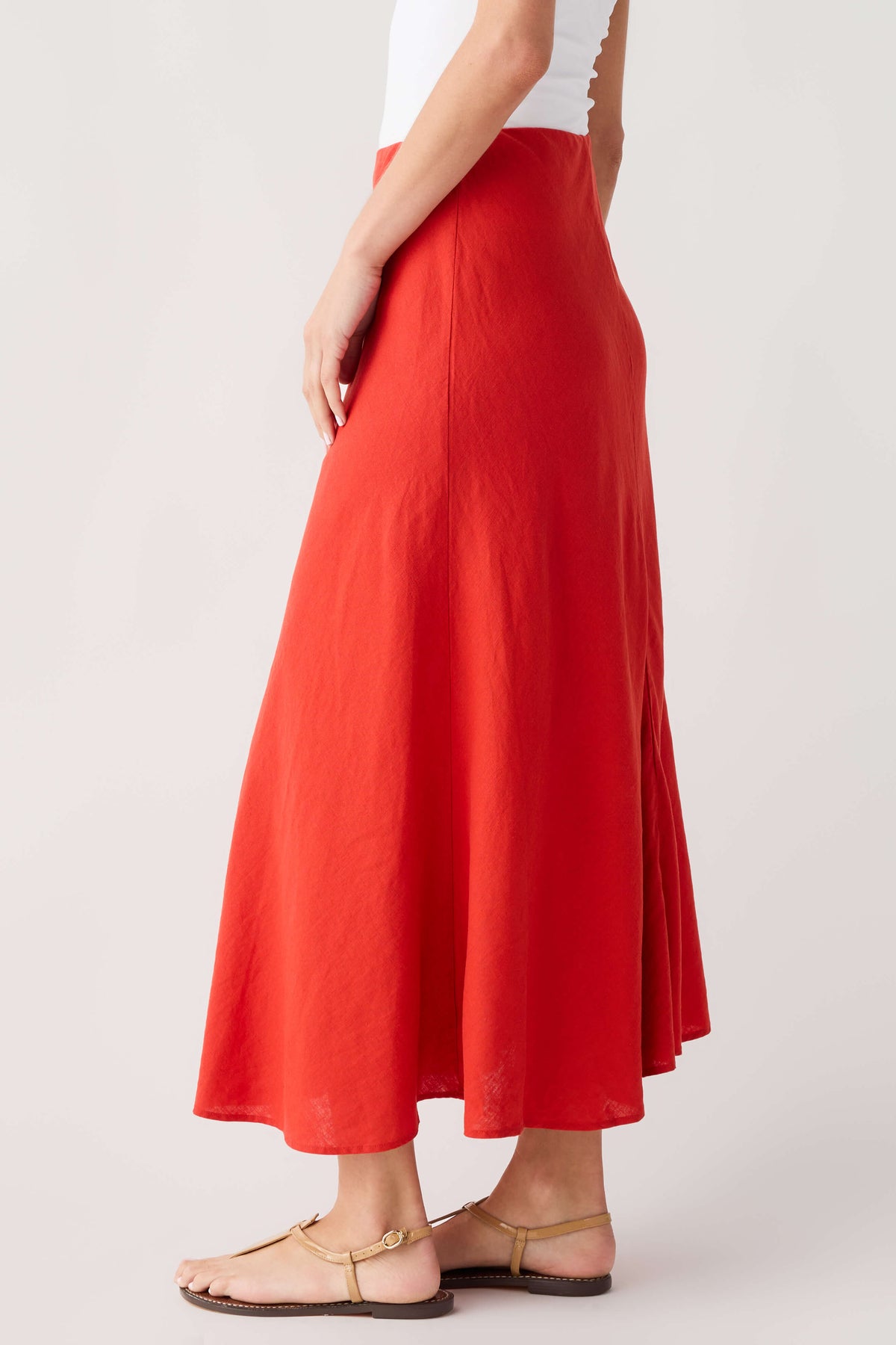 Red midi A-line skirt, draped side view with softly flared hem