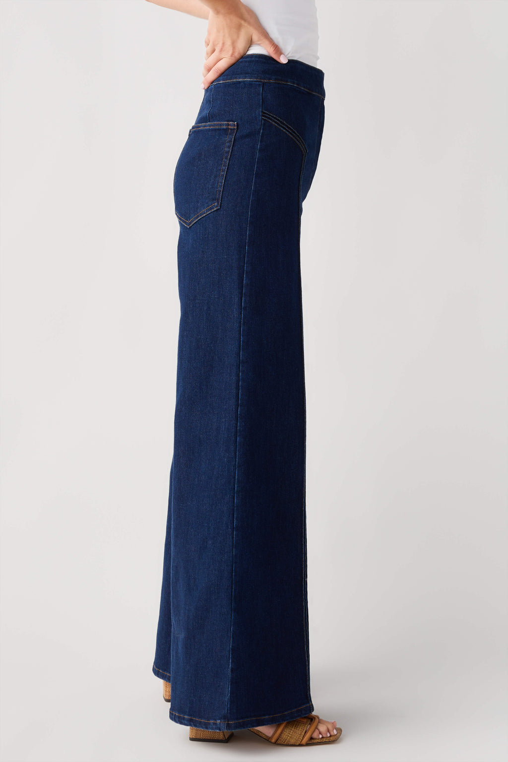 High-waisted dark denim flare pants, side view, with front patch pockets