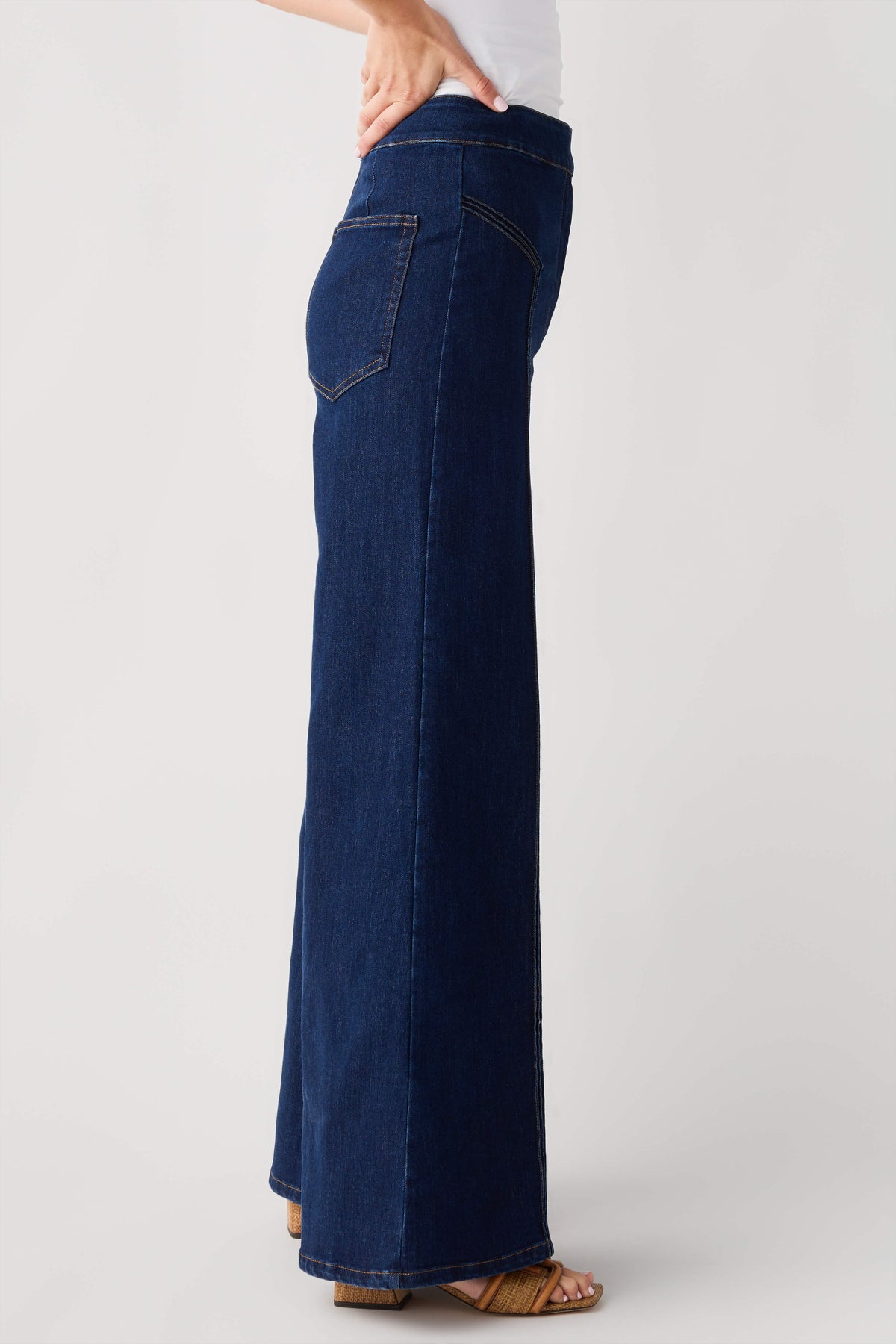 High-waisted dark denim flare pants, side view, with front patch pockets