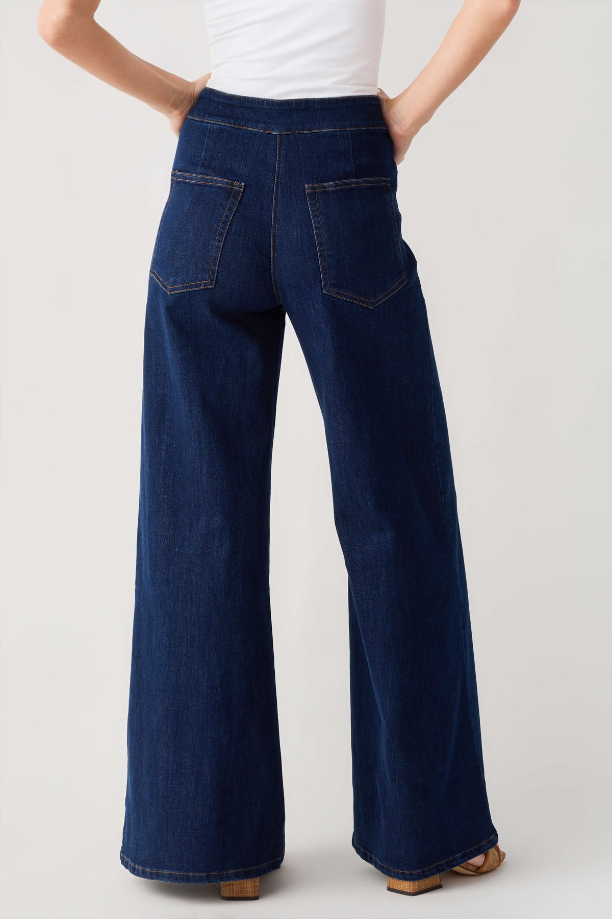 High-waisted dark denim flare pants with front patch pockets and wide legs