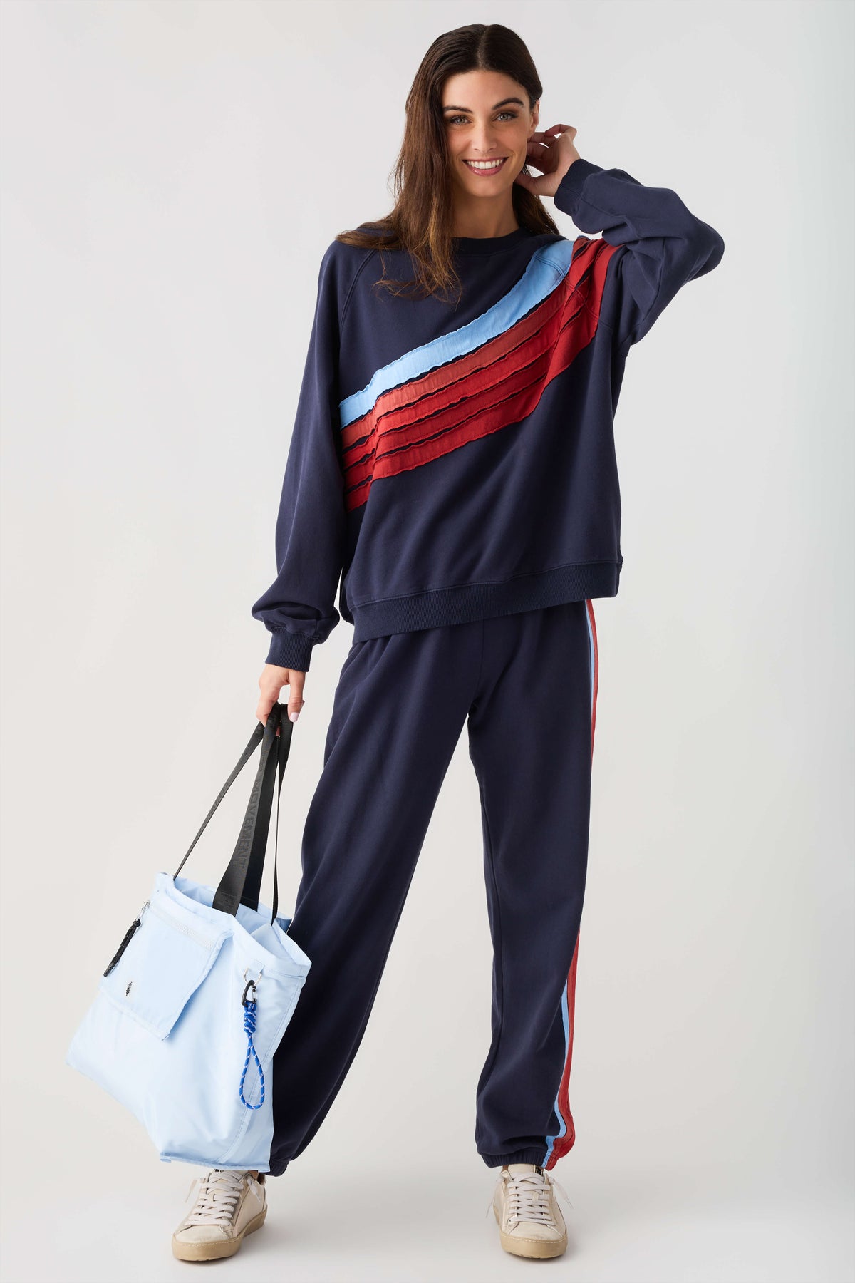 Navy sweatshirt with light blue and red diagonal stripe panel, relaxed crew neck