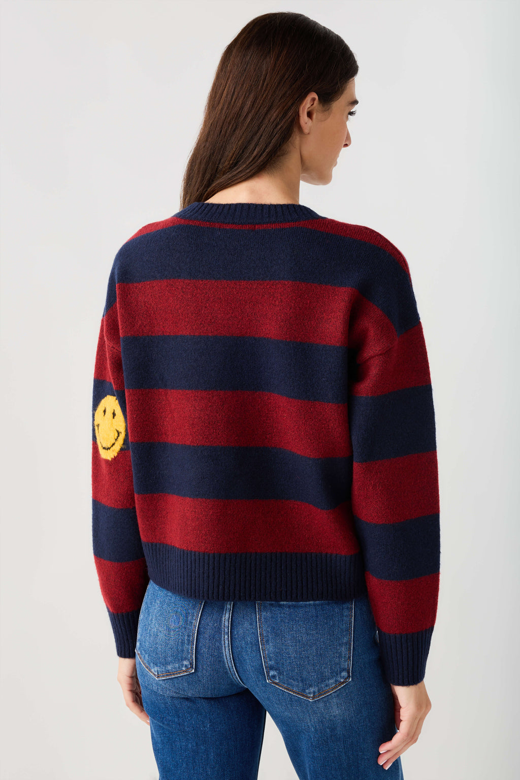 Striped smiley face sweater in navy and burgundy stripes, smiley graphic on back