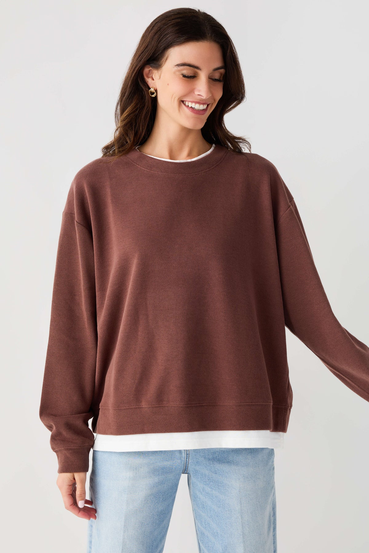 Crewneck pullover sweatshirt in chocolate brown with ribbed cuffs and white hem band.