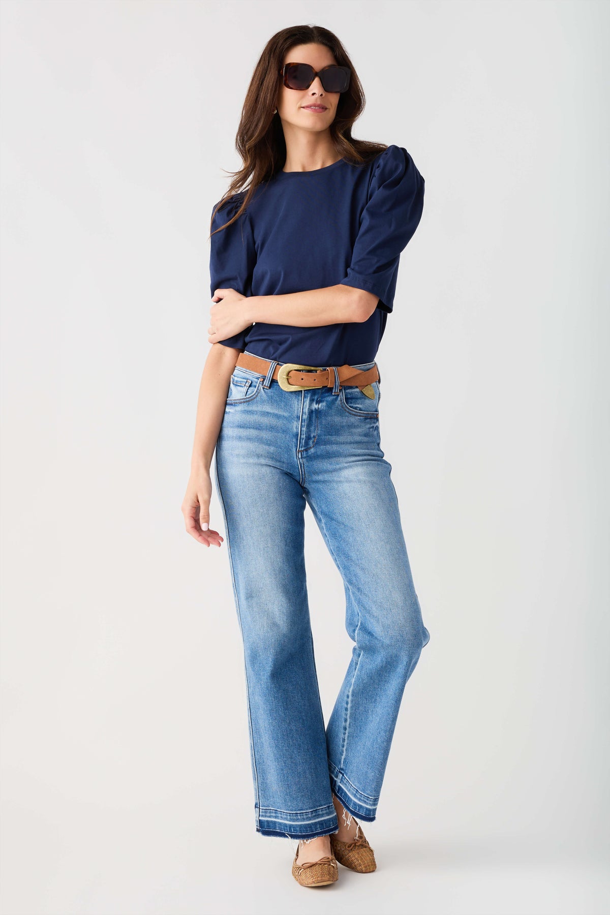 Cognac suede belt with oval gold buckle, worn with blue jeans