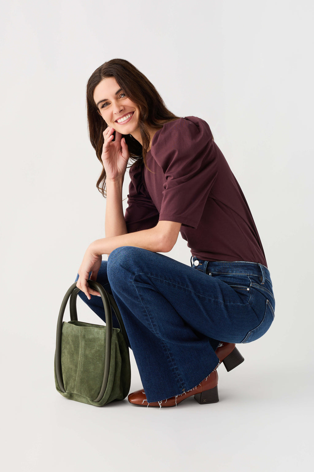 Olive bucket bag with open top, short handles, and front pocket detail