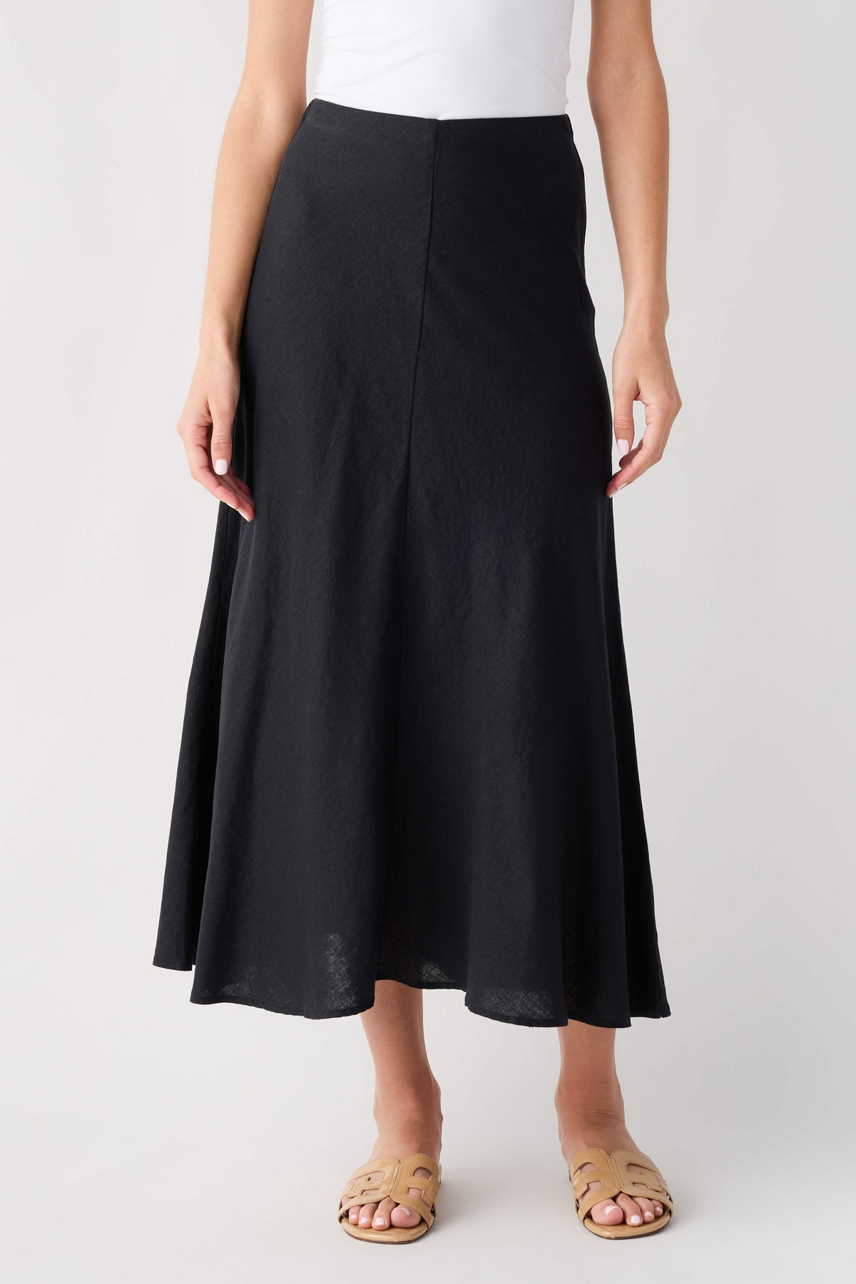 Black midi A-line skirt with center seams and flared silhouette