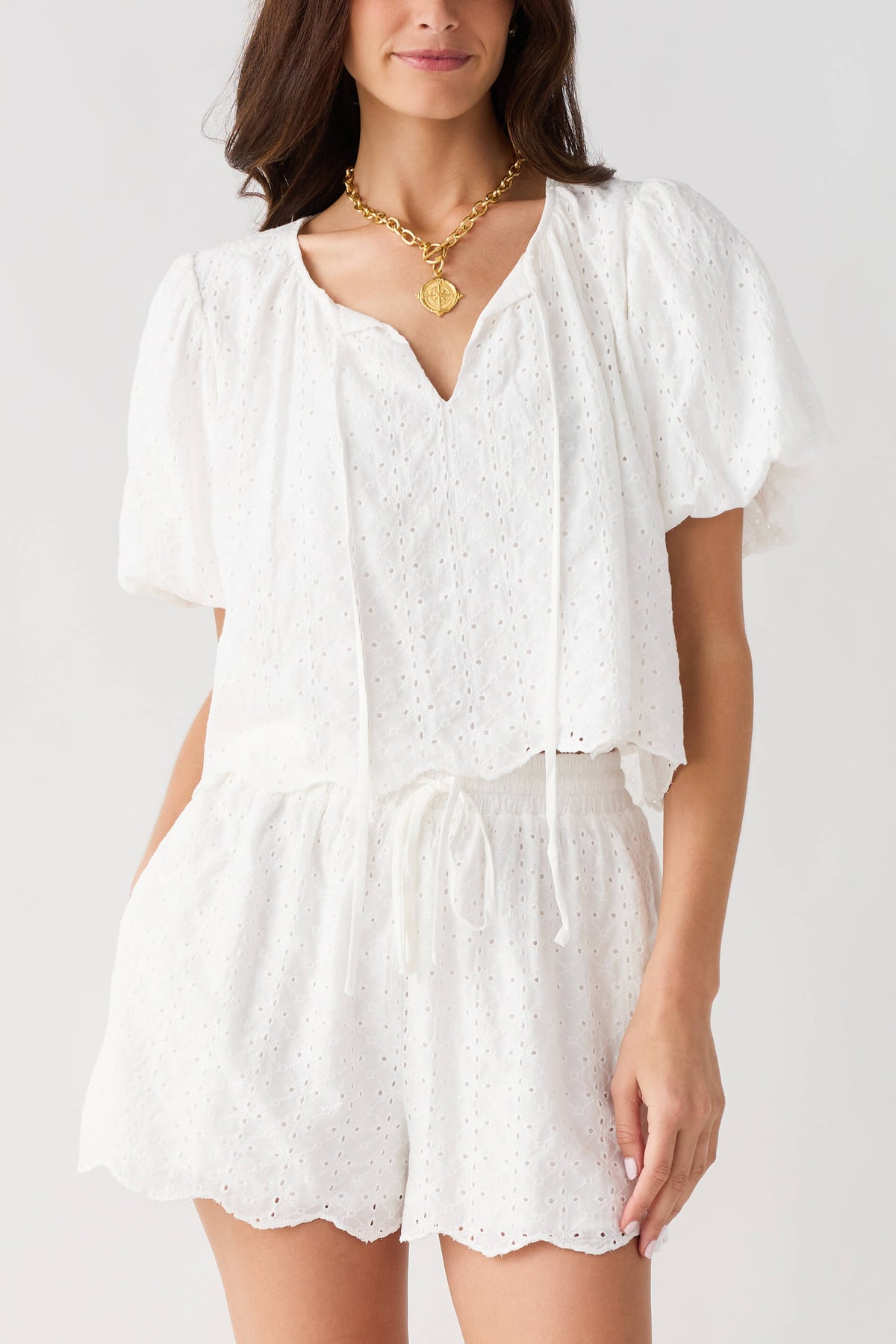 Off white eyelet lace top and shorts set with V-neck, puff sleeves, and gathered waist