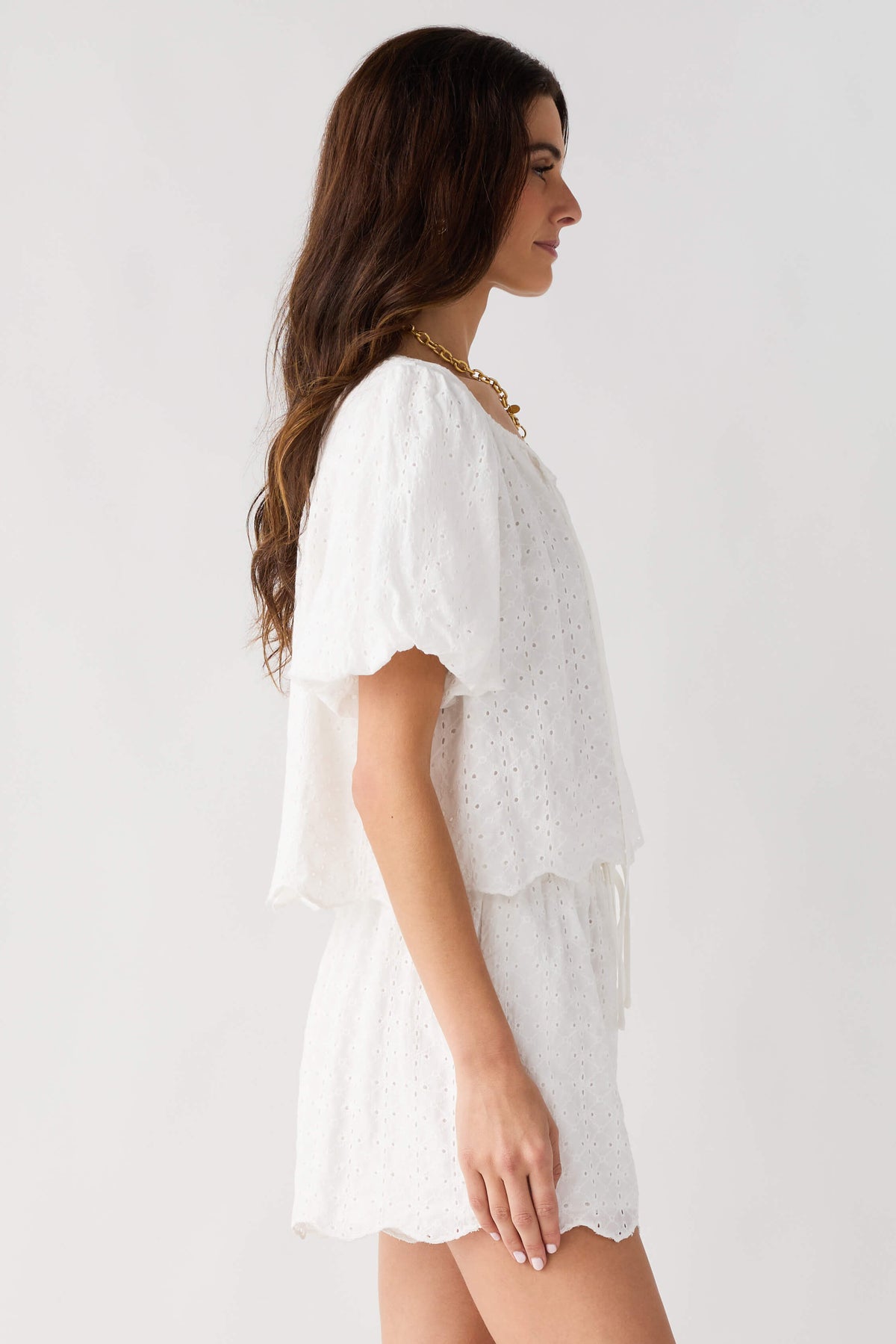 Off white eyelet lace top and shorts set from side view with puff sleeves and tiered hem