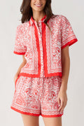 Red and white border-print short set top close-up with button-front placket and vertical panel