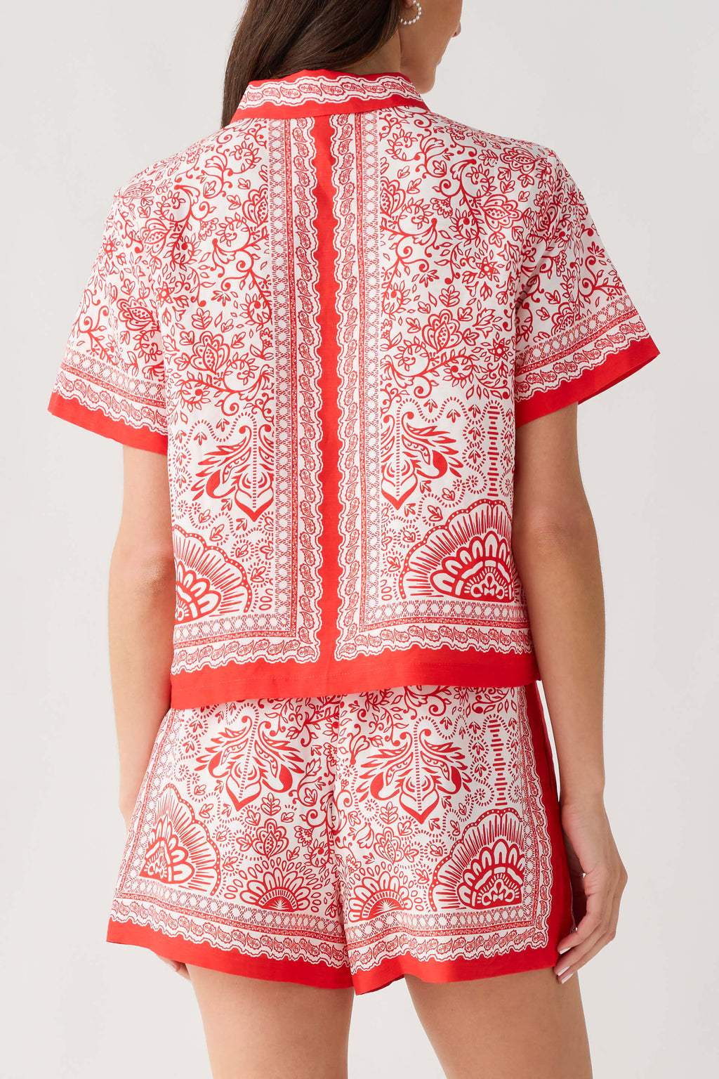 Red and white border-print short set back view: matching shorts with printed border hem